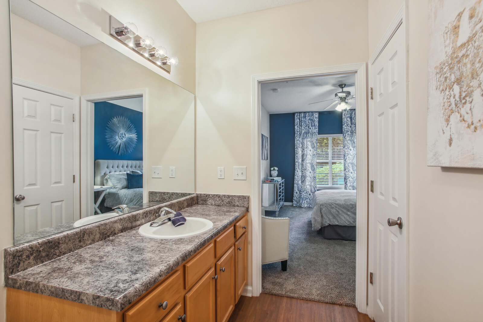 model bathroom with ample lighting leading to bedroom