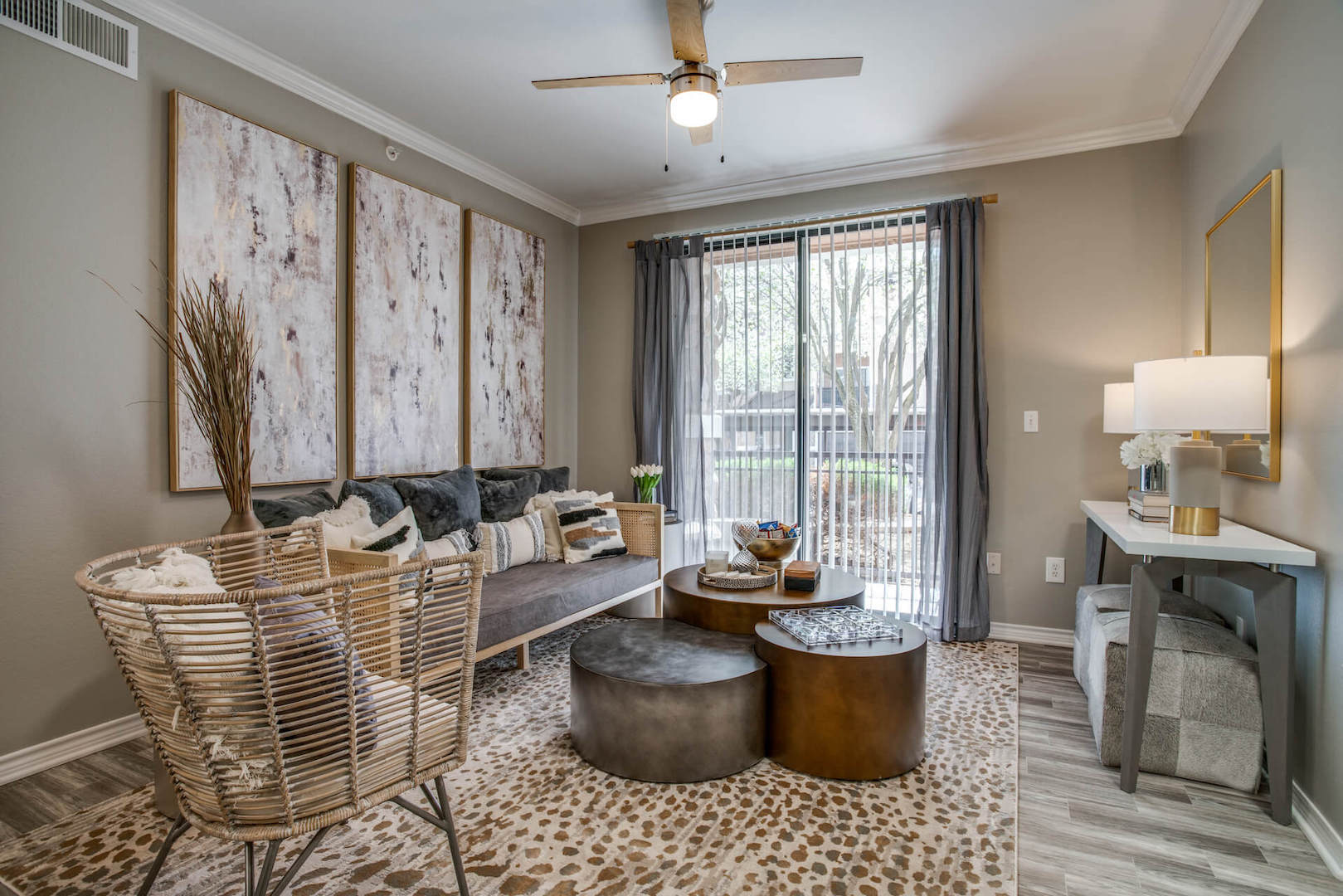 model living room with modern furniture, ceiling fan and ample modern lighting
