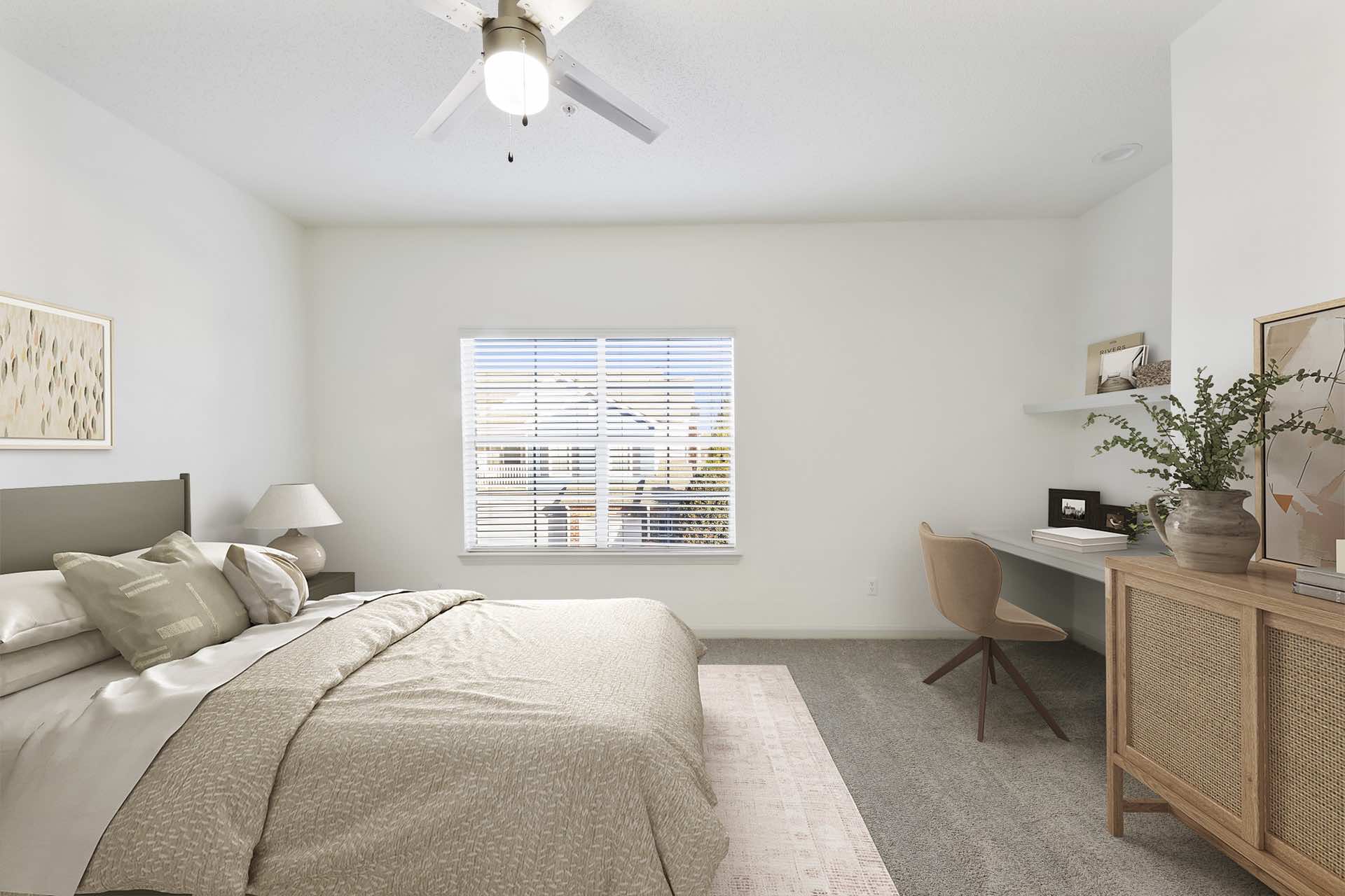 carpeted bedroom with modern bedding, wall art, desk and natural lighting through window