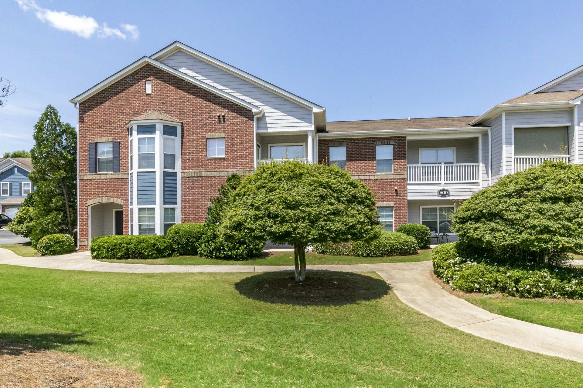 green grass area on side of two-story apartment building